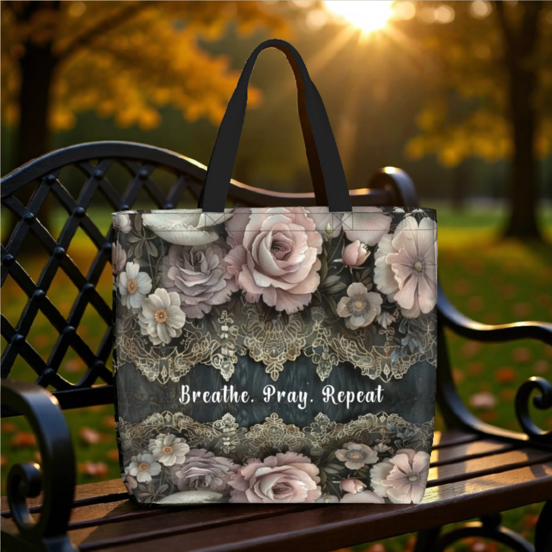 Dark, dramatic, and completely stunning, with the words "Breathe, Pray, Repeat". This large zippered tote bag features a romantic floral design — blush and dusty pink roses in full bloom, layered with delicate gold lace trim detailing against a deep charcoal background. It's bold, feminine, and unlike anything you'll find on the high street.